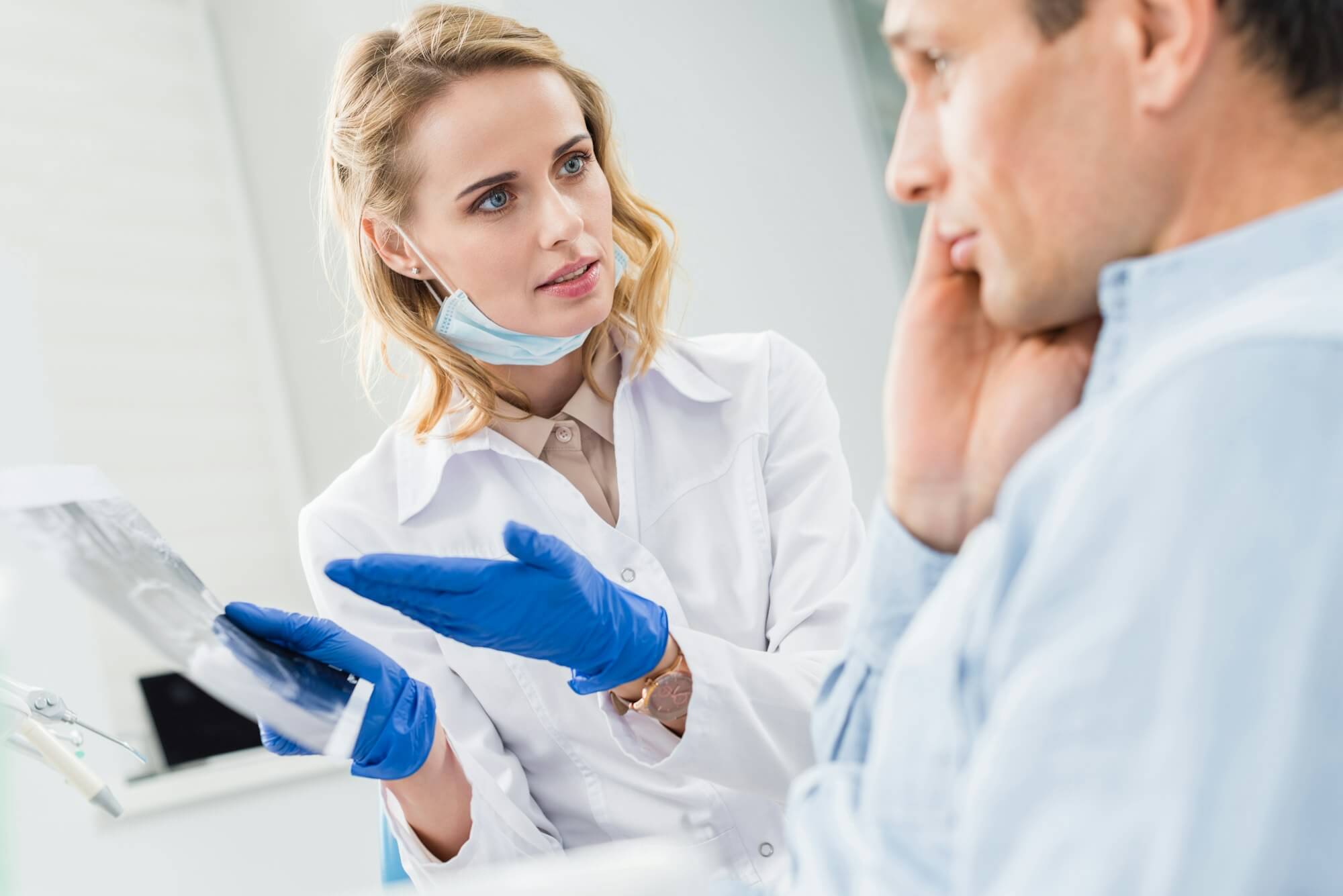 man-consulting-with-dentist-looking-at-x-ray-in-modern-clinic.jpg